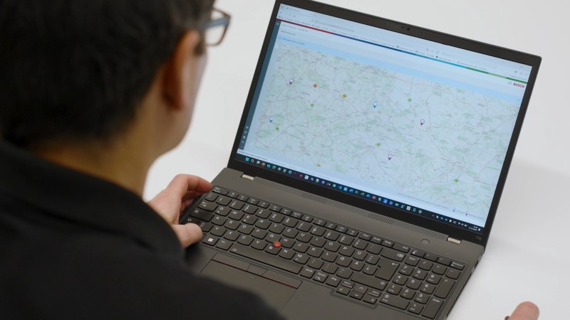 Ein Mitarbeiter der auf dem Laptop eine Kartenübersicht anschaut.
